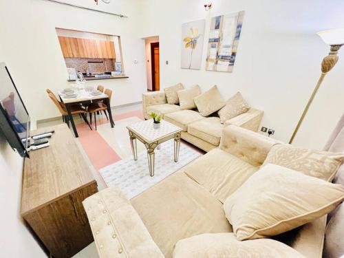 a living room with a couch and a table at Stay at Al Ghaimah Holiday Homes 1 Bedroom Apartment Near Airport in Dubai
