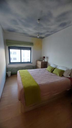 a bedroom with a large bed and a window at Paim Maria in Ponta Delgada