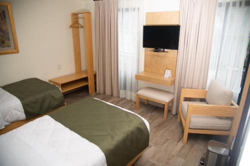 a hotel room with a bed and a chair at Quinta Mercedes in Guanajuato