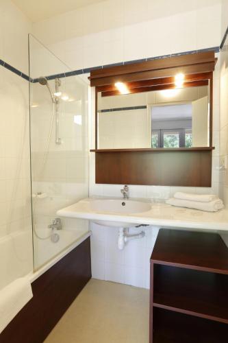 une salle de bain avec un lavabo, une douche et un miroir dans l'établissement Vacancéole - Le Domaine de Chames - Pont d'Arc, à Vallon-Pont-dʼArc