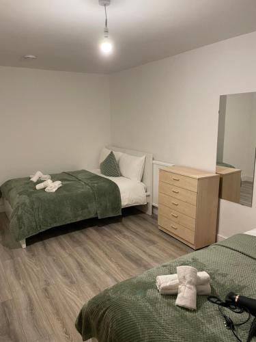 - une chambre avec 2 lits et une commode dans l'établissement Lovely Triple and Quadruple Bedrooms in Euston, à Londres