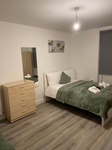 a bedroom with a bed and a dresser in it at Lovely Triple and Quadruple Rooms in Euston & Square in Central London in London