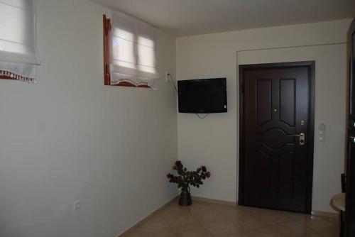 a room with a door and a vase with flowers next to it at Nikos Apartments in Ioannina