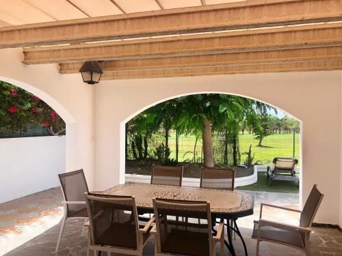 ein Esszimmer mit einem Tisch und Stühlen sowie eine Terrasse in der Unterkunft Villas Las Almenas in Maspalomas