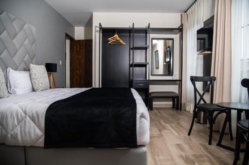 a bedroom with a bed and a table and a chair at Quinta Mercedes in Guanajuato