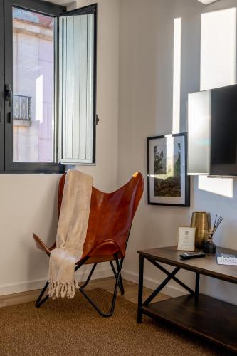 a living room with a chair and a table at Apartamentos do Mercado in Covilhã