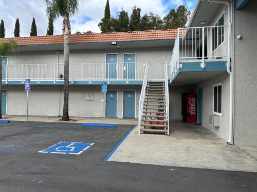 a building with a staircase next to a parking lot at Villa Inn Anaheim in Anaheim