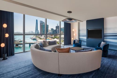 a living room with a large couch and a large window at W Sydney in Sydney