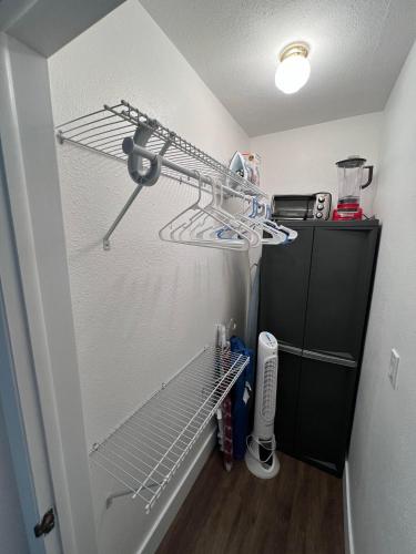 a kitchen with a shelf and a refrigerator at Cozy private studio w/own yard - 3mi from Beach in Seminole