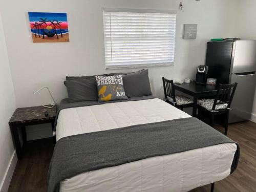 a bedroom with a bed and a table and a desk at Cozy private studio w/own yard - 3mi from Beach in Seminole