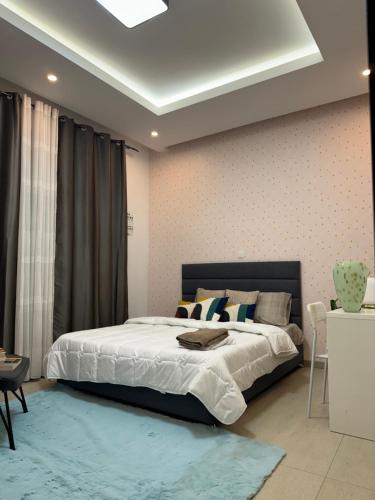 a bedroom with a large bed with a blue rug at Dream of a Butterfly in Dakar