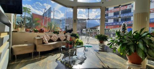 ein Wohnzimmer mit einem Sofa und Topfpflanzen in der Unterkunft Gran Hotel Palmeras in Jaén