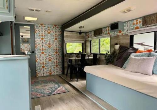 Happy Camper - Close to Mackinac Island في Carp Lake: غرفة نوم مع سرير وغرفة طعام