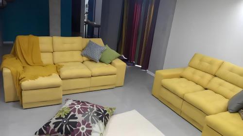 a yellow couch and chair in a living room at Recanto dos Sonhos in Paraty