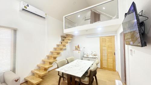 a dining room with a table and a staircase at The3 Happiness Nordic Private Home in Nakhon Phanom