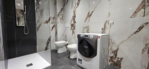 a bathroom with a toilet and a toilet paper dispenser at il Cortiletto 2 apartments in Calolziocorte