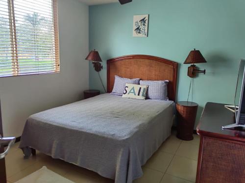 a bedroom with a bed and two lamps and a television at 2Bed 2Bath Jaco Costa Linda in Jacó