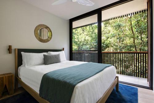 a bedroom with a bed and a large window at Moonrise & Starfall in Byron Bay