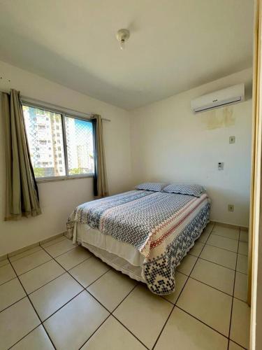 ein Schlafzimmer mit einem Bett in der Ecke eines Zimmers in der Unterkunft Apartamento Clube 3/4 com Ar-condicionado in Aracaju