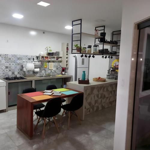 a kitchen with a table and chairs and a refrigerator at Recanto dos Sonhos in Paraty
