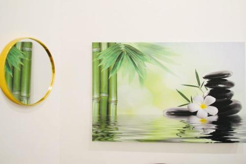 a painting of a palm tree and a mirror at Comfortable Rooms in AKH Area in Vienna