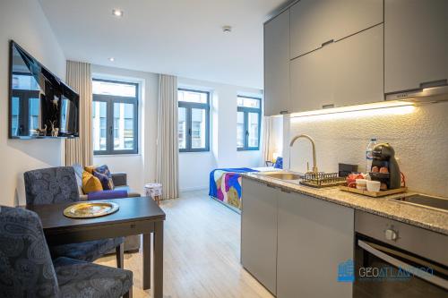 een keuken met een spoelbak en een woonkamer bij Porto Formosa Central Lofts in Porto