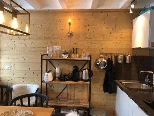 cocina con paredes de madera y encimera con fregadero en Appartement au pied des pistes, en La Plagne
