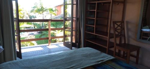a bedroom with a view of a window and a bed at Estalagem Capitão Gancho in Praia do Rosa