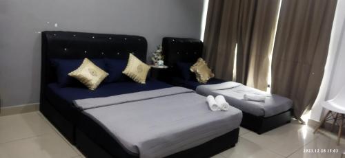 a bedroom with two beds with pillows on them at Syanaz Studio Apartment in Gua Musang
