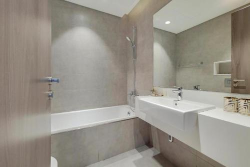 a bathroom with a sink and a bathtub and a sink and a mirror at MBR CITY One Brdoom Apatment in Dubai