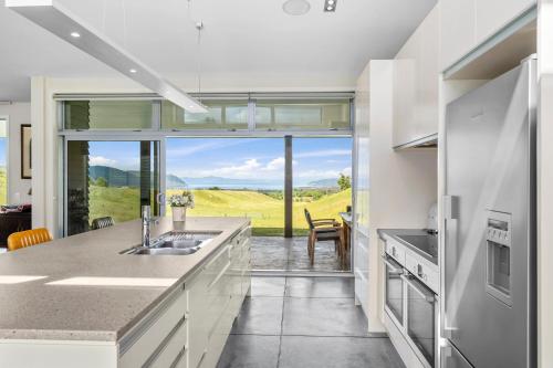 a kitchen with white cabinets and a large window at Hepina Heights Retreat - Kinloch in Kinloch