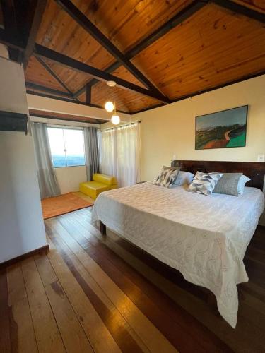 a bedroom with a large bed and a wooden ceiling at Chalé Panorâmico in Ouro Preto