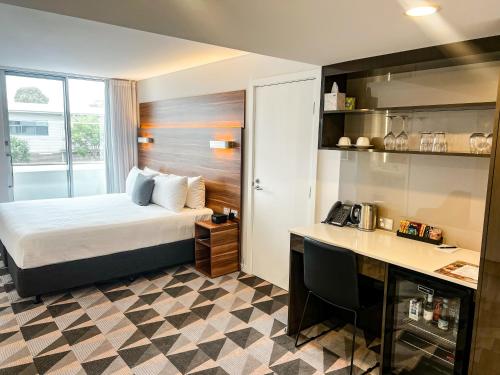 グリフィスにあるThe Gem Hotelのベッドと机があるホテルの部屋