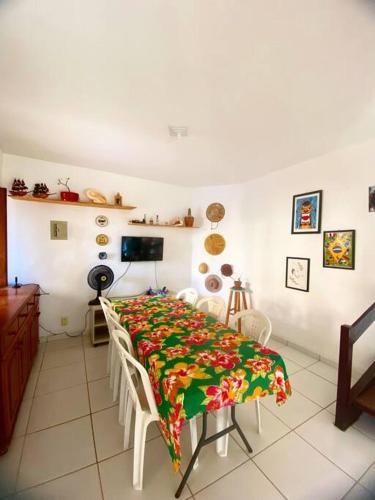 une salle à manger avec une table et un tissu de table fleuri dans l'établissement Duplex relax, à Barra de São Miguel