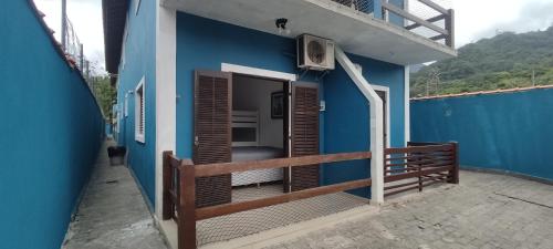 a blue house with a balcony with a balcony at Flat Maresias 50m da Praia - 02 Mar & Tur in Maresias