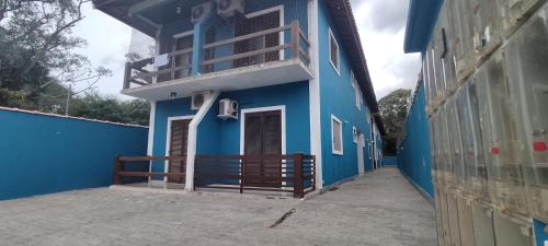 a blue building with a balcony on the side of it at Flat Maresias 50m da Praia - 02 Mar & Tur in Maresias