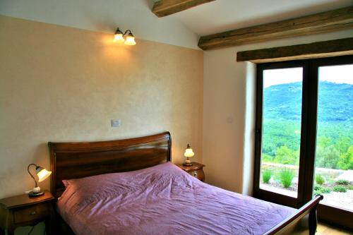 a bedroom with a bed and a large window at Family friendly house with a swimming pool Bartolici, Central Istria - Sredisnja Istra - 21934 in Livade