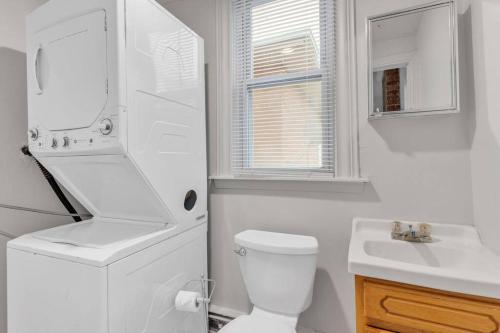 a white bathroom with a toilet and a sink at Frog Hollow Red Door Loft in Hartford