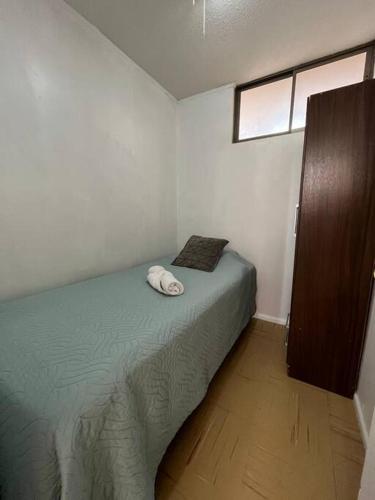 een kleine slaapkamer met een bed en een raam bij Departamento equipado 124 Ovalle in Ovalle