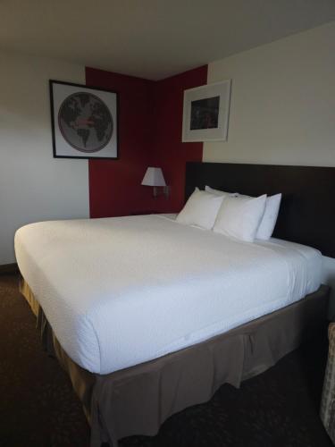 a large white bed in a hotel room at Ramada by Wyndham SeaTac Airport in SeaTac