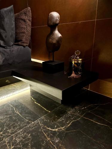 a black table with a statue on it in a room at Monte dos Domos in Gameleiras