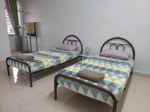 two twin beds in a room with at Azzalia Homestay Karak Bentong with 4 Rooms 3 Aircond NJOI in Karak