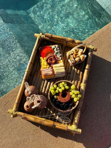 a tray of food on a table next to the water at Monte dos Domos in Gameleiras
