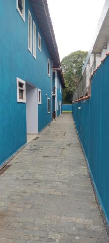 an empty alley between two blue buildings at Flat Maresias 50m da Praia - 06 Mar & Tur in Maresias