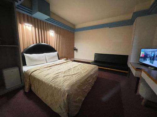 桃園區的住宿－溫情自助旅店，配有一张床和一台平面电视的酒店客房