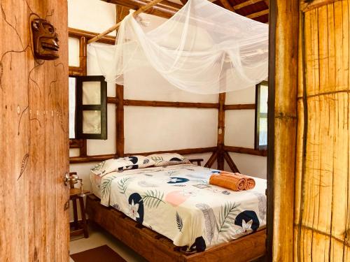 sypialnia z łóżkiem z baldachimem w obiekcie La Caleta w mieście Mompiche