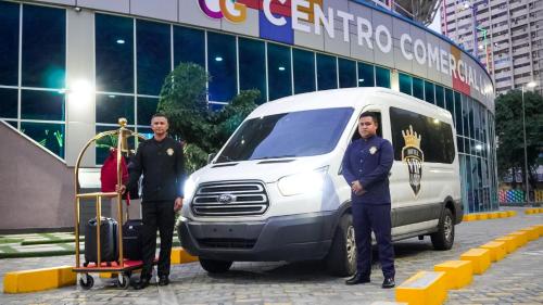 two men standing next to a white van in front of a building at Hotel Vip La Guaira in Macuto