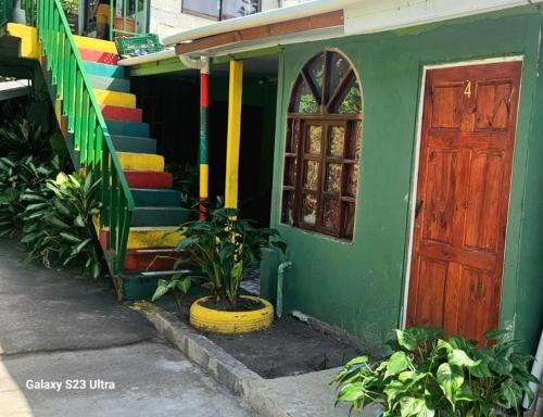una casa colorida con una puerta y una planta delante en Tortuguero Casa de Playa Green House en Tortuguero