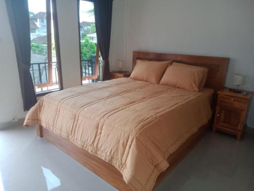 1 dormitorio con 1 cama grande y cabecero de madera en Chiinta House, en Ubud