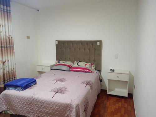 una camera con un letto con due cuscini sopra di Bello y acogedora casa -departamento habitaciones a Lima